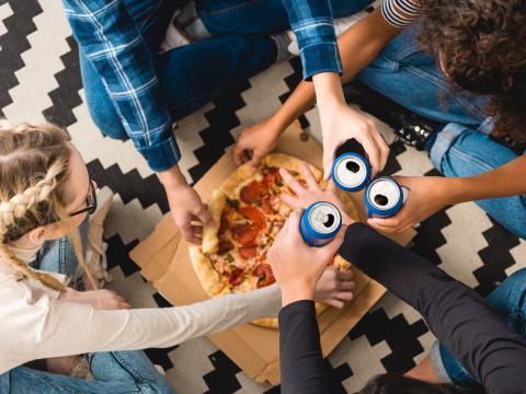 People sharing pizza and soda. 