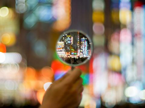 Hand holding magnifying glass.