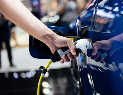 Person charging an electric vehicle. 